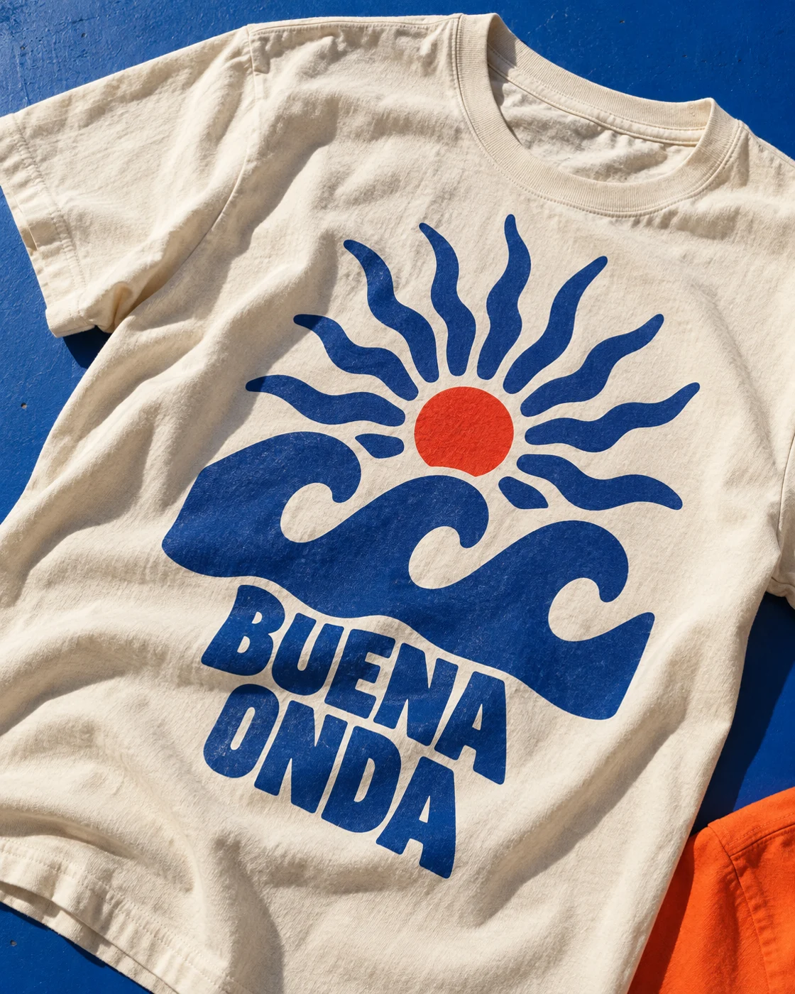 Idea de personalización: una camiseta con un sol, olas azules y el mensaje Buena Onda